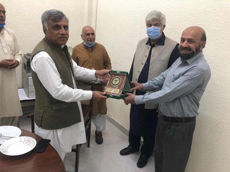 Vice chancellor presenting shield to retired employees on their retirement